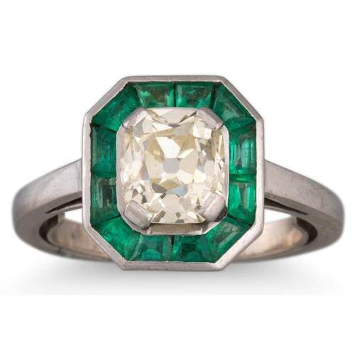 112 - AN ANTIQUE DIAMOND AND EMERALD TARGET RING, the cushion cut diamond to calibré emerald surround, Fre... 