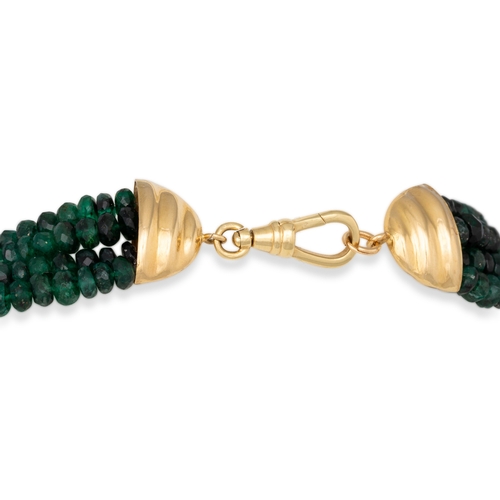 140 - A THREE STRANDED FACETED BEADED EMERALD NECKLACE, the graduated coloured emeralds to a 18ct yellow g... 