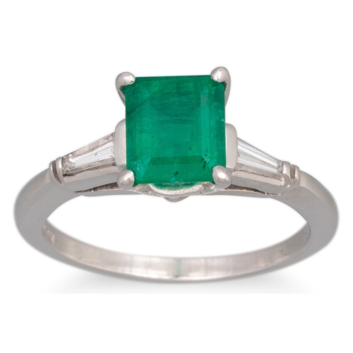 195 - AN EMERALD AND DIAMOND RING, the rectangular emerald to tapered baguette diamond shoulders, mounted ... 