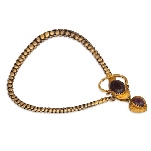 29 - A GOLD VICTORIAN SNAKE BRACELET, garnet set suspending heart shaped locket, 19 g.