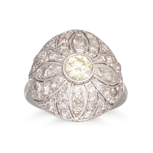 295 - A DIAMOND CLUSTER RING, of bombe form, set with a brilliant cut diamond to an old cut diamond surrou... 