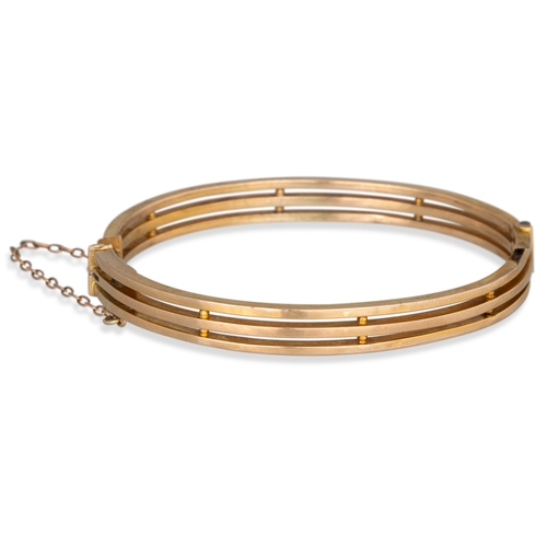 242 - AN ANTIQUE GOLD HINGED BANGLE, integrated clasp and safety chain, 7.8 g.