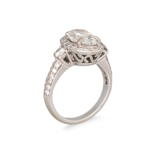 320 - A DIAMOND SOLITAIRE RING, the oval diamond to diamond surround and shoulders, mounted in white gold.... 