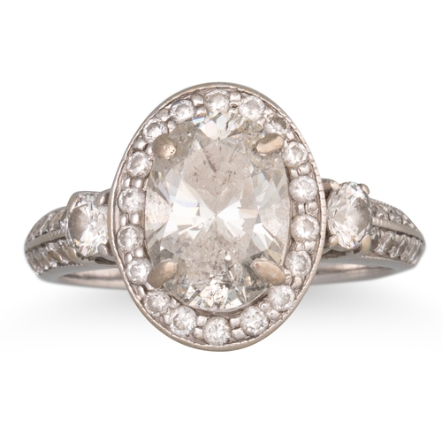 320 - A DIAMOND SOLITAIRE RING, the oval diamond to diamond surround and shoulders, mounted in white gold.... 