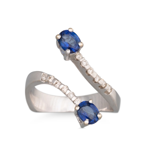 130 - A DIAMOND AND SAPPHIRE RING, of cross-over design, mounted in 18ct white gold. Estimated: weight of ... 