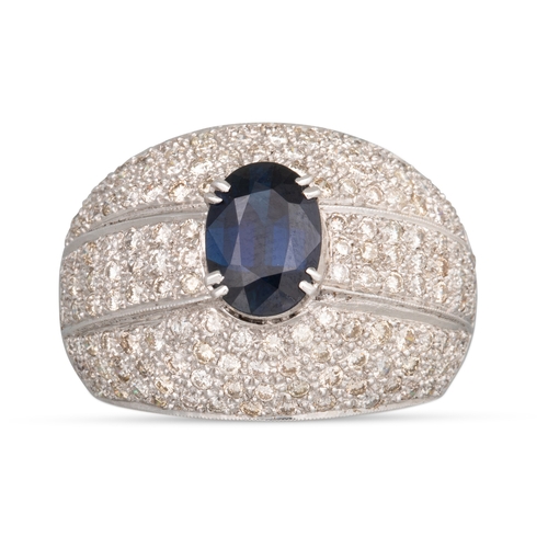 146 - A SAPPHIRE AND DIAMOND RING, the oval sapphire to a pavé diamond bombé surround, mounted in 18ct whi... 