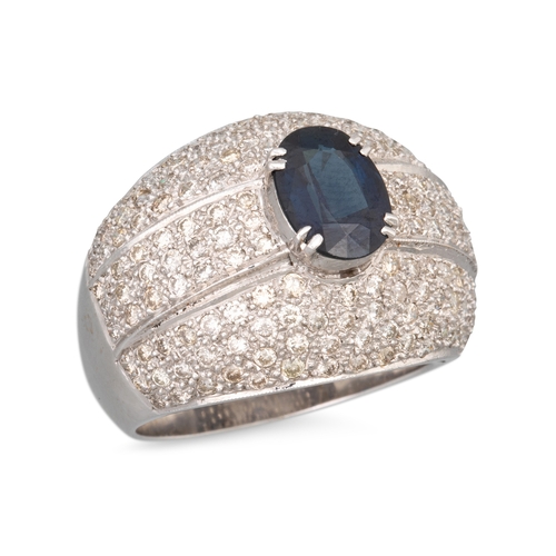 146 - A SAPPHIRE AND DIAMOND RING, the oval sapphire to a pavé diamond bombé surround, mounted in 18ct whi... 