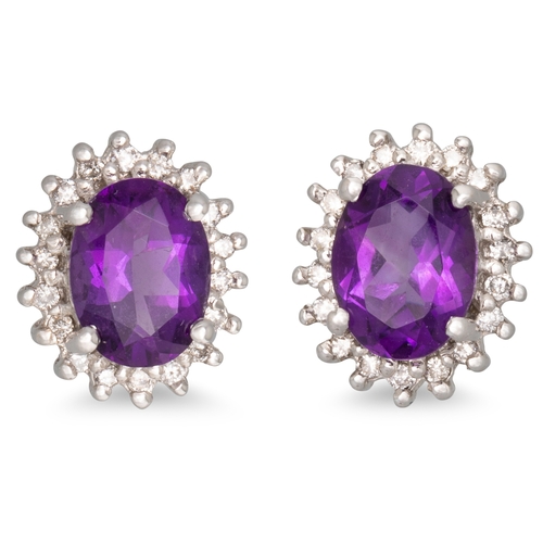 31 - A PAIR OF AMETHYST AND DIAMOND CLUSTER EARRINGS, the oval amethyst to diamond surround, mounted in 1... 