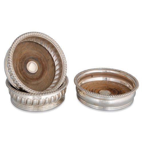 404 - A PAIR OF ANTIQUE SILVER PLATED WINE COASTERS, with gadrooned sides, and a modern silver plated wine... 