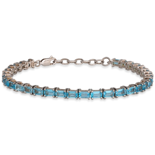 53 - A TOPAZ TENNIS BRACELET, the rectangular set topaz mounted in silver