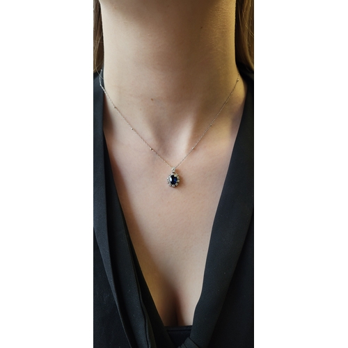 132 - A DIAMOND AND SAPPHIRE CLUSTER PENDANT, the oval sapphire to diamond surround, mounted in 14ct white... 