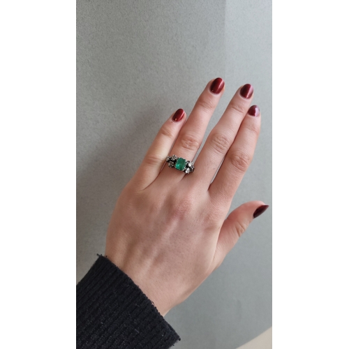 138 - A GEORGIAN EMERALD AND DIAMOND RING, the trap cut emerald to rose cut diamond shoulders, closed back... 