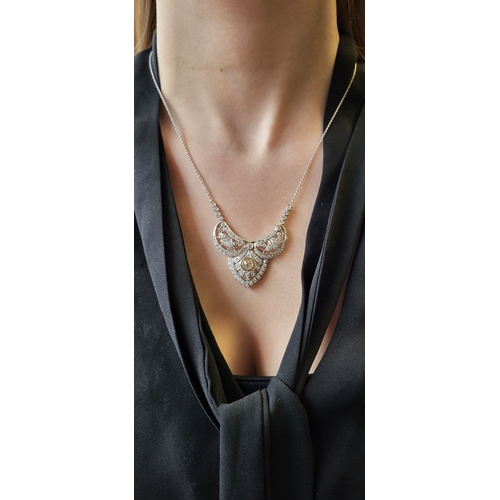 144 - A DIAMOND NECKLACE, the central shaped open work diamond set plaque to back chain, in white gold. Es... 