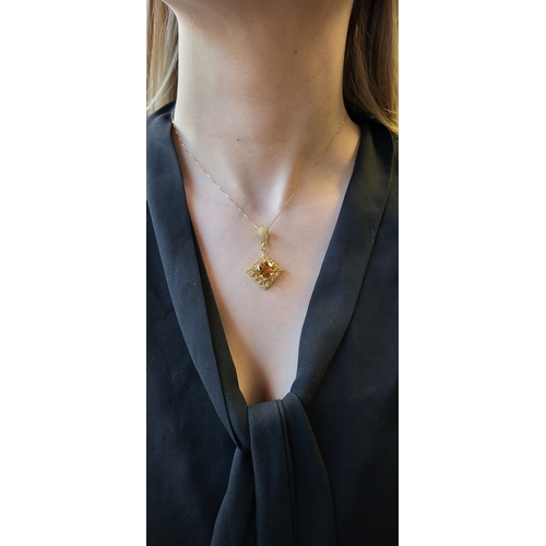 198 - A CITRINE PENDANT, to an 18ct yellow gold wire work mount, on an 18ct gold chain