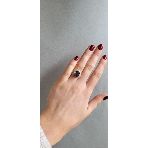 242 - A GARNET AND DIAMOND RING, the cushion cut garnet to diamond shoulders, in white gold, size O
... 