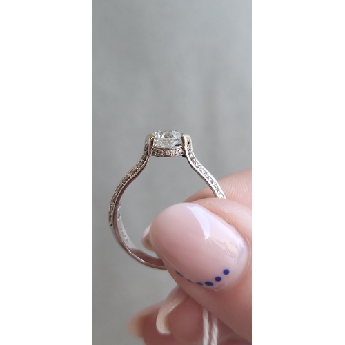 159 - A DIAMOND SOLITAIRE RING, the central round brilliant cut diamond to diamond shoulders, mounted in g... 