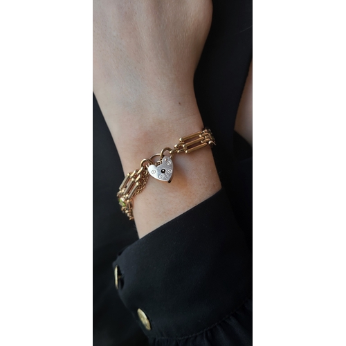 26 - A 9CT GOLD GATE BRACELET, set with peridot, padlock clasp & safety chain, bracelet: 7