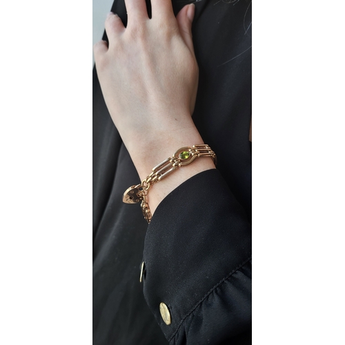 26 - A 9CT GOLD GATE BRACELET, set with peridot, padlock clasp & safety chain, bracelet: 7