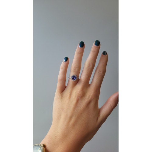 141 - A TANZANITE AND DIAMOND CLUSTER RING, of circular form to diamond shoulders, mounted in 18ct white g... 