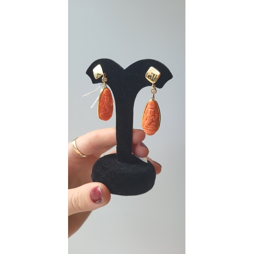 176 - A PAIR OF CORAL DROP EARRINGS, with carved figures, mounted in 18ct yellow gold, 2