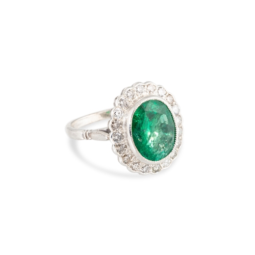 39 - AN EMERALD AND DIAMOND SET CLUSTER RING, the central oval emerald to diamond set surround, mounted i... 