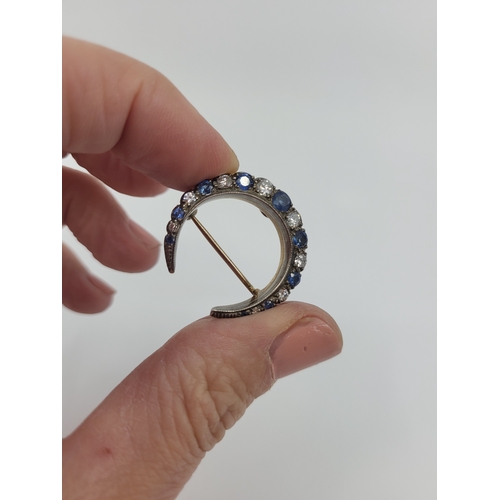355 - AN ANTIQUE DIAMOND AND SAPPHIRE CRESCENT BROOCH, mounted in silver & gold