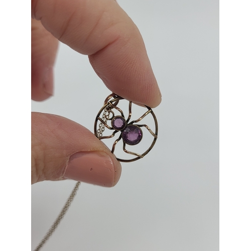 395 - AN ANTIQUE INSECT PENDANT, modelled as a spider, set with amethyst, stamped 9ct on a 9ct gold chain