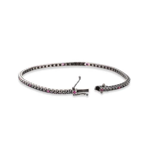 112 - A BLACK DIAMOND AND RUBY LINE BRACELET, mounted in black rhodium-plated 18ct gold. Estimated: weight... 