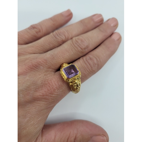 75 - AN ANTIQUE AMETHYST RING, with a table cut amethyst, rococo style decoration to the shoulders, mount... 