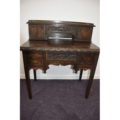 284 - HEAVILY CARVED GOTHIC GEORGIAN LADIES DESK THE TOP WITH  CARVED DOORS AND BANK OF 3 DRAWERS BEHIND E... 