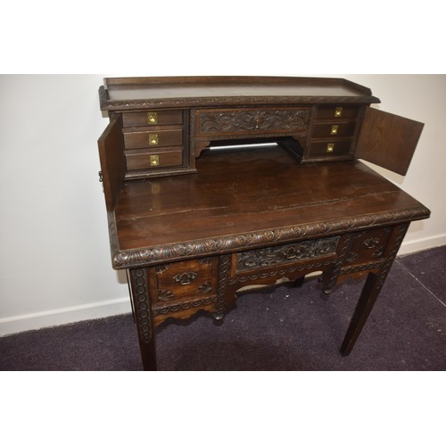 284 - HEAVILY CARVED GOTHIC GEORGIAN LADIES DESK THE TOP WITH  CARVED DOORS AND BANK OF 3 DRAWERS BEHIND E... 