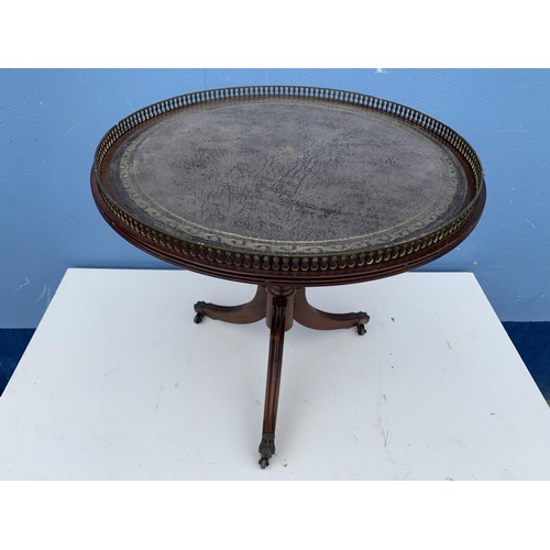 110 - A ROUND LEATHER TOP PEDESTAL TABLE WITH BRASS GALLERY