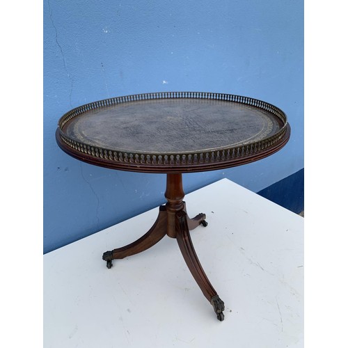 110 - A ROUND LEATHER TOP PEDESTAL TABLE WITH BRASS GALLERY