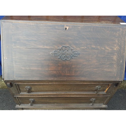 150 - AN ANTIQUE OAK WRITING BUREAU ON HEAVY LEGS