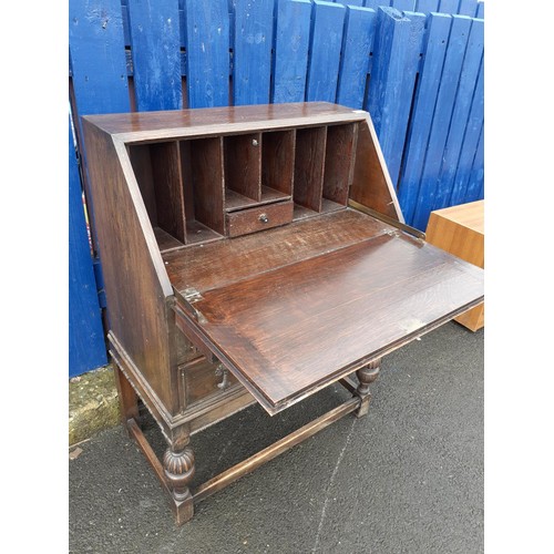 150 - AN ANTIQUE OAK WRITING BUREAU ON HEAVY LEGS
