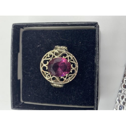 236 - A SILVER OPENWORK AND PURPLE STONE RING