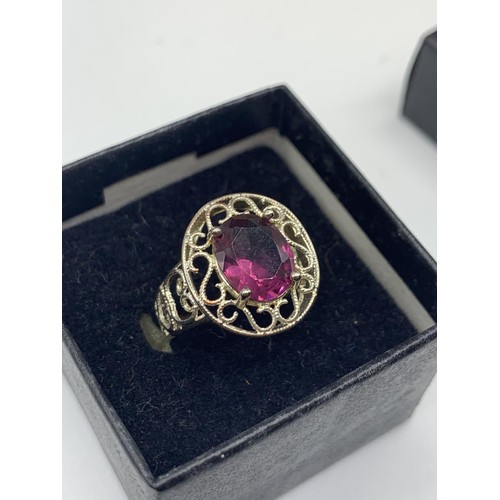 236 - A SILVER OPENWORK AND PURPLE STONE RING