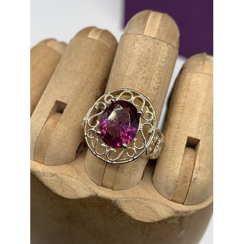 236 - A SILVER OPENWORK AND PURPLE STONE RING