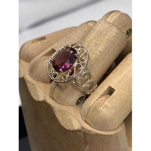 236 - A SILVER OPENWORK AND PURPLE STONE RING