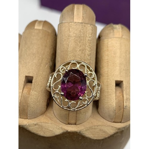 236 - A SILVER OPENWORK AND PURPLE STONE RING