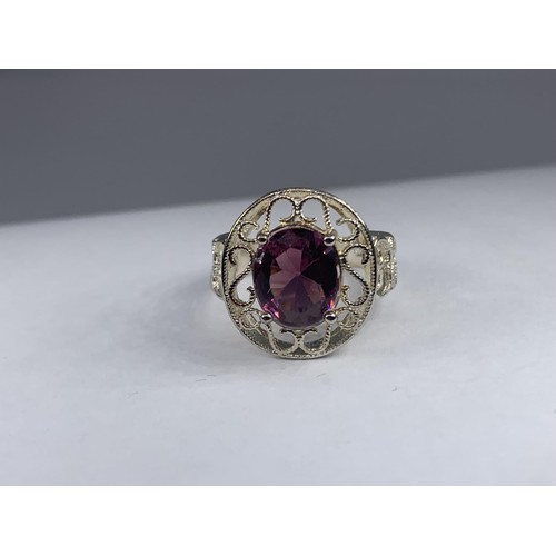 236 - A SILVER OPENWORK AND PURPLE STONE RING