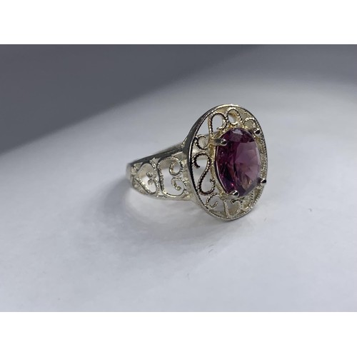 236 - A SILVER OPENWORK AND PURPLE STONE RING