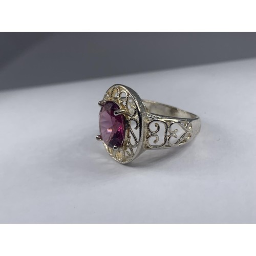 236 - A SILVER OPENWORK AND PURPLE STONE RING