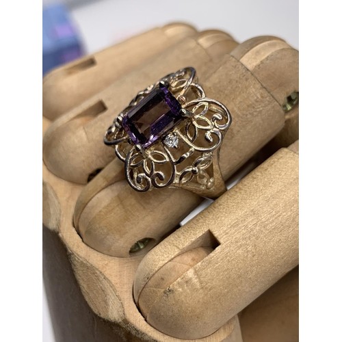 341 - A SILVER OPENWORK & PURPLE STONE RING