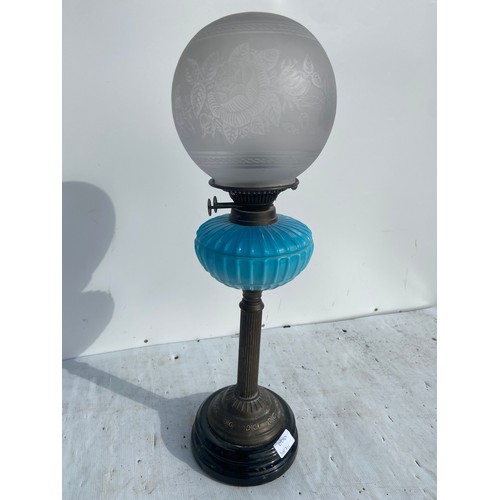 716 - A BLUE PORCELAIN BOWL OIL LAMP ON BRASS PILLAR WITH AN ETCHED GLASS FOOTBALL SHADE