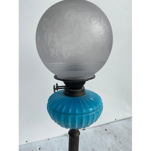 716 - A BLUE PORCELAIN BOWL OIL LAMP ON BRASS PILLAR WITH AN ETCHED GLASS FOOTBALL SHADE