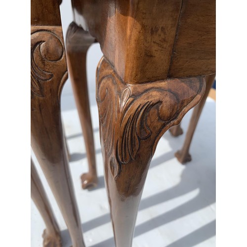 711 - ANTIQUE SHAPED WALNUT NEST OF TABLES ON A PAW FOOT