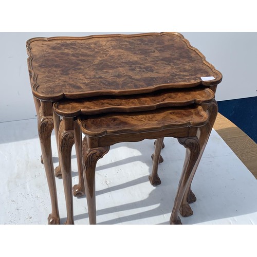 711 - ANTIQUE SHAPED WALNUT NEST OF TABLES ON A PAW FOOT