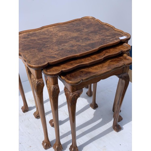 711 - ANTIQUE SHAPED WALNUT NEST OF TABLES ON A PAW FOOT