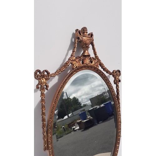 702 - AN ORNATE GILT BEVELL EDGE MIRROR